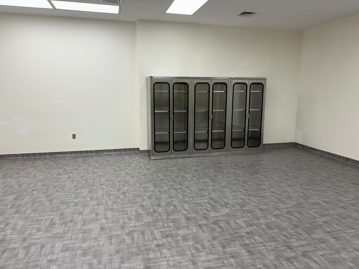 Tall wall cabinet with glass doors installed for university lab and morgue supply storage, Model 1034-3C